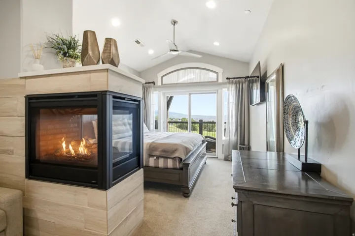 Three-sided fireplace with light wood-finish tile surround and white mantel