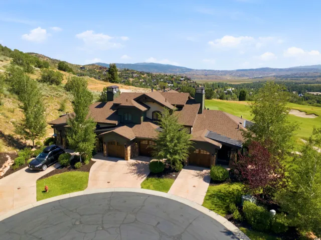 Stunning hilltop residence featuring a multi-level stone and wood exterior with prominent peaked rooflines and multiple chimneys