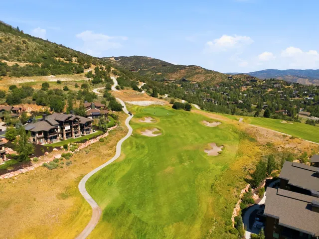 Stunning aerial view showcasing an 18-hole championship golf course with manicured fairways, strategically placed bunkers, and mature tree-lined borders