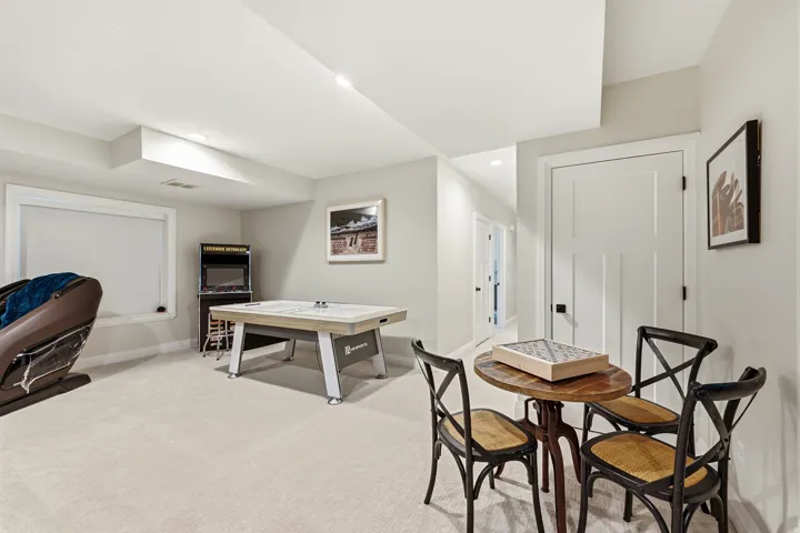 Spacious recreation area featuring plush carpeting and recessed lighting