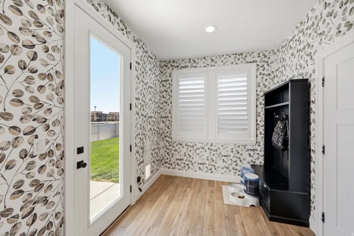 Entryway featuring a full-light exterior door, wood-finish flooring, and decorative wallpaper