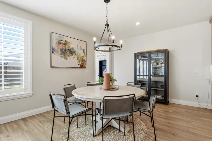 Dining area featuring wood-finish flooring, recessed lighting, and a window with plantation shutters