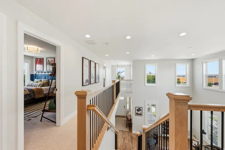 Multi-level interior featuring a wood-finish staircase with black metal balusters and natural wood newel posts