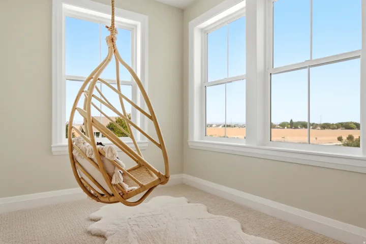 Bright room featuring multiple double-hung windows with white trim, neutral wall paint, and light-colored carpeting
