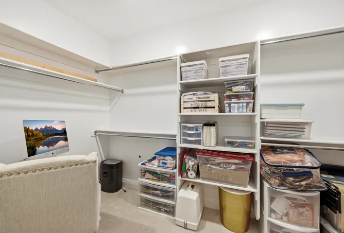 Closet room featuring built-in shelving, ample hanging rods, and carpet flooring