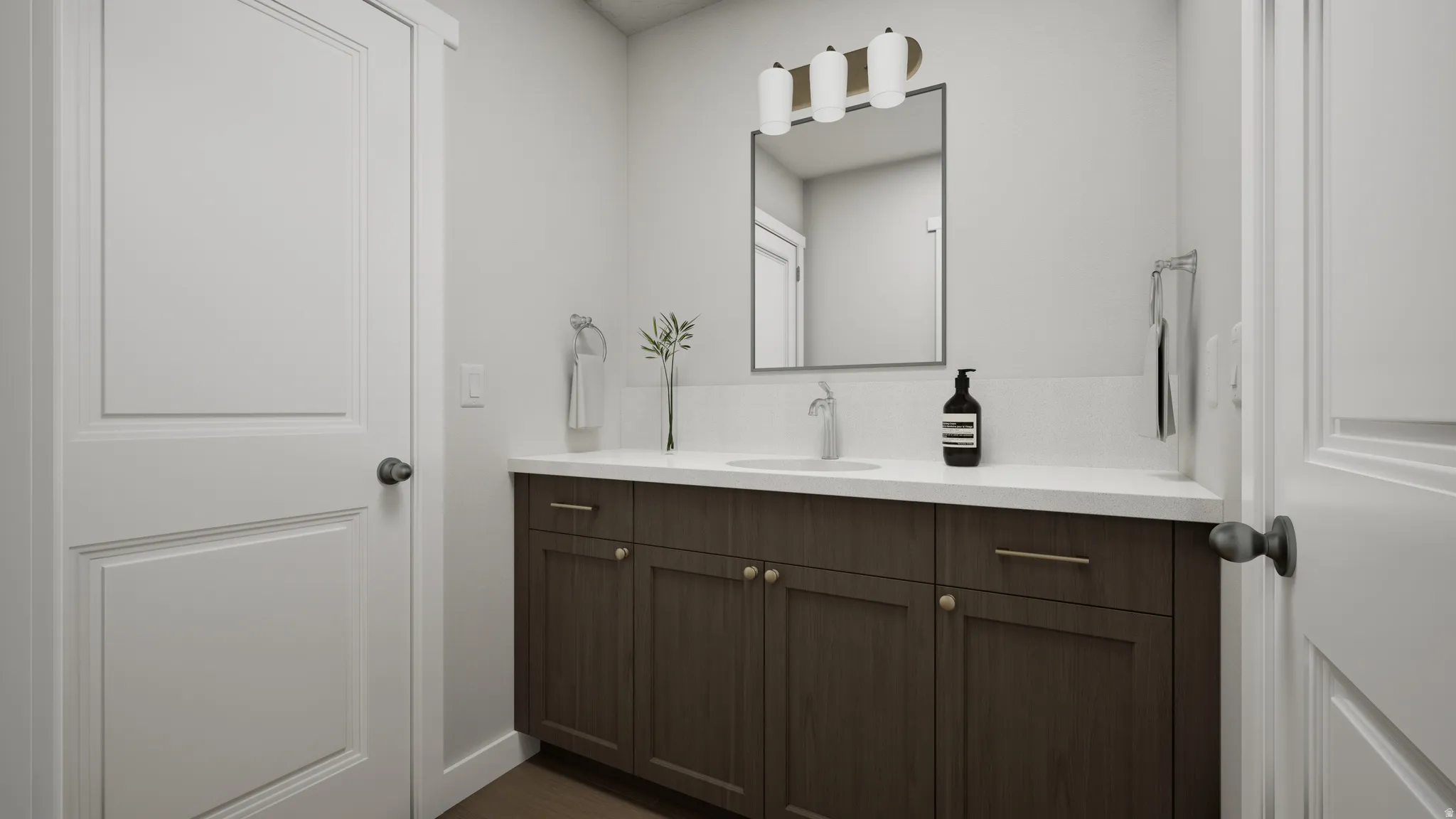 Vanity with dark wood-finish cabinetry, white countertop, and integrated sink