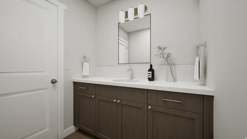 Wood-finish vanity with a white countertop and integrated sink, complemented by a rectangular mirror and a contemporary three-light fixture