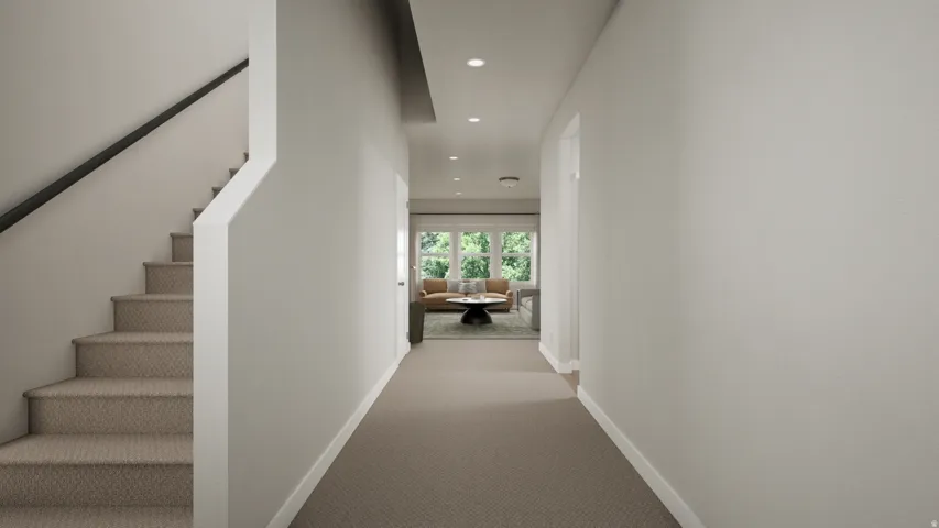 Bright hallway with recessed ceiling lighting, neutral wall finishes, and neutral-tone carpeting leading to a bright window-lit space