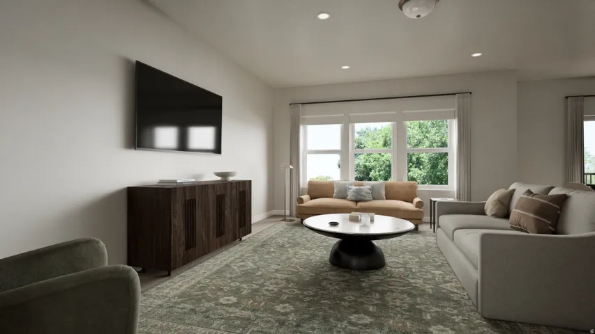Bright living area featuring multiple windows, recessed lighting, and wood-finish flooring