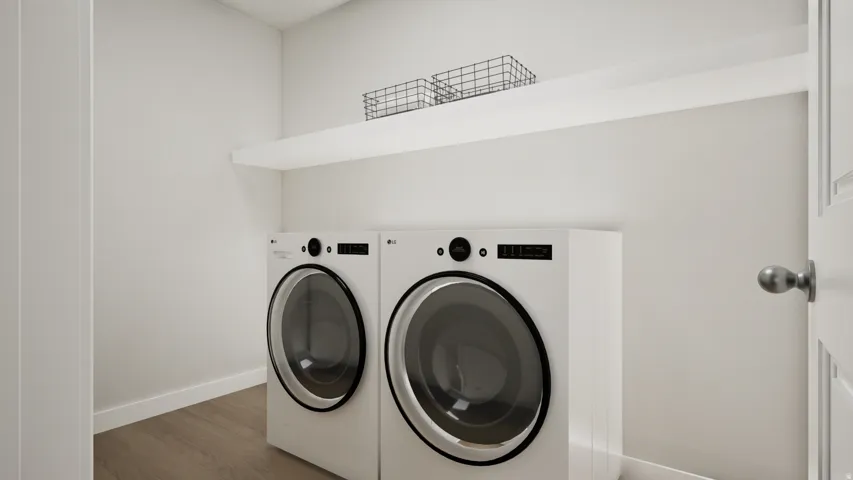 Dedicated laundry space featuring a floating shelf, wood-finish flooring, and crisp white walls