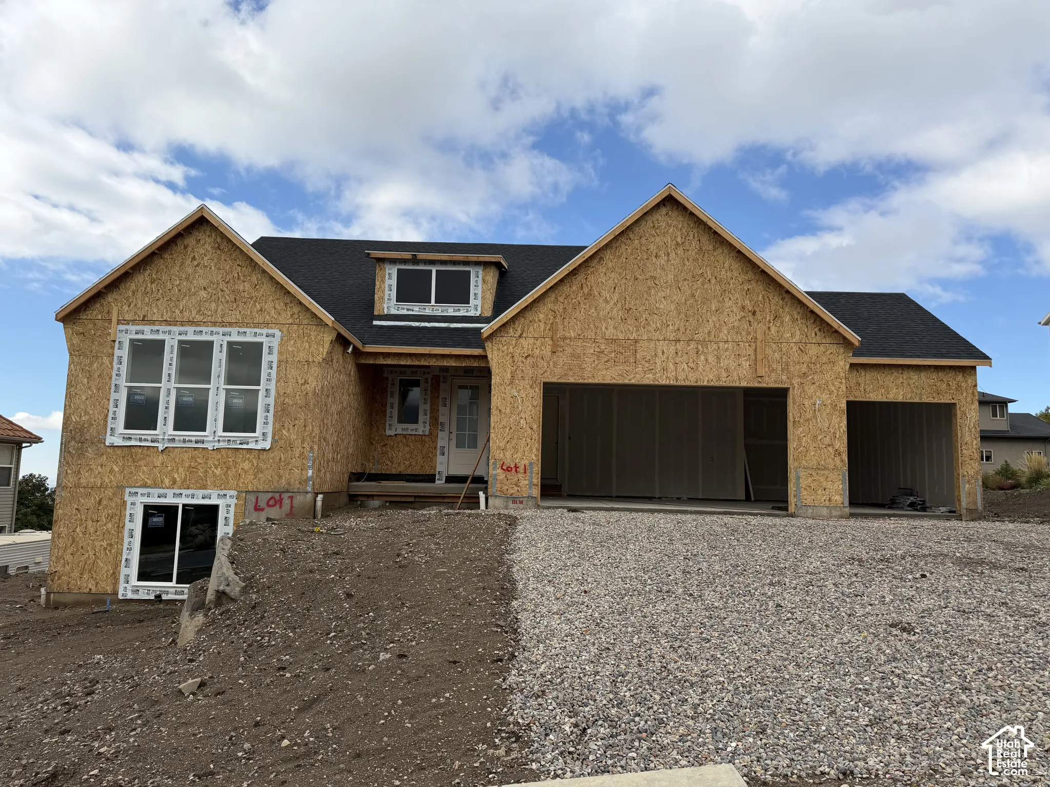 New construction exterior featuring asphalt shingle roofing, oriented strand board sheathing, multi-pane windows, a recessed entryway, and a three-car garage configuration