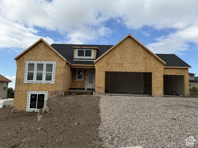 New construction exterior featuring a multi-gabled roofline, dark asphalt shingle roofing, dual-bay garage, and white-framed windows