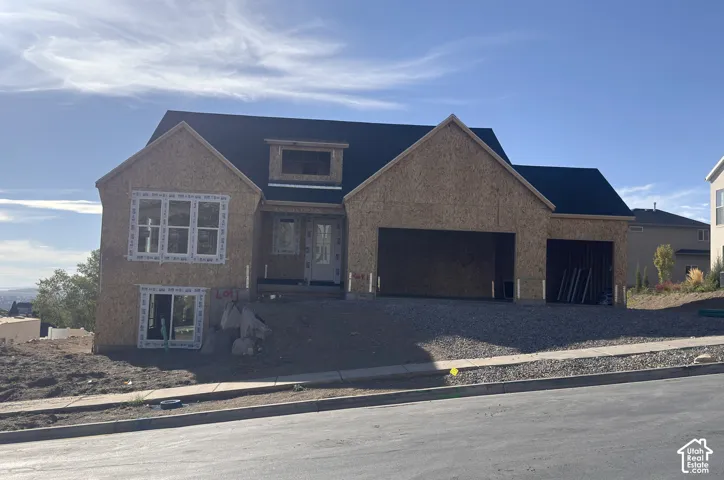 Newly constructed residence featuring a multi-gable roofline, attached two-car garage, and upper-level dormer window
