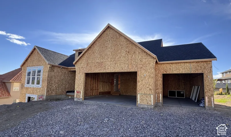 New construction residential structure featuring a multi-gable roofline, dark shingle roofing, and an integrated three-car garage
