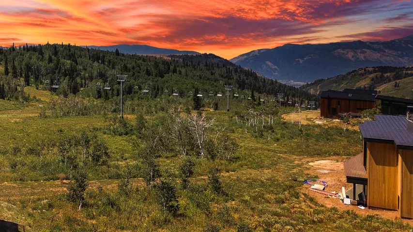 Sunset view from building lot with mountain landscape with ski lift infrastructure available with direct access from back of building lot.
