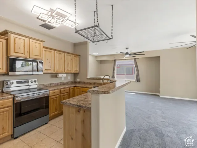 Kitchen featuring wood-finish cabinetry, stainless steel appliances, and a breakfast bar