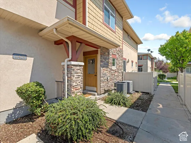 Entryway featuring stacked stone accents, a covered porch, and a solid wood-finish door