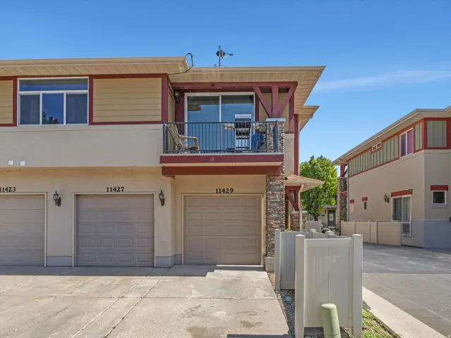 Multi-story exterior with a ground-level garage and upper-level balcony