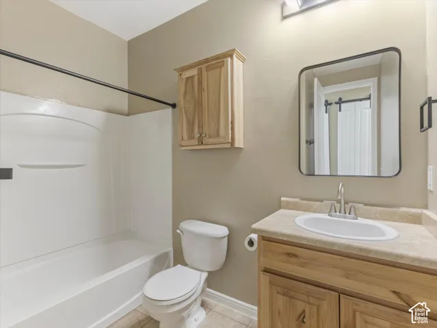 Bathroom featuring a white bathtub, wood-finish vanity with an integrated sink, and a rectangular mirror