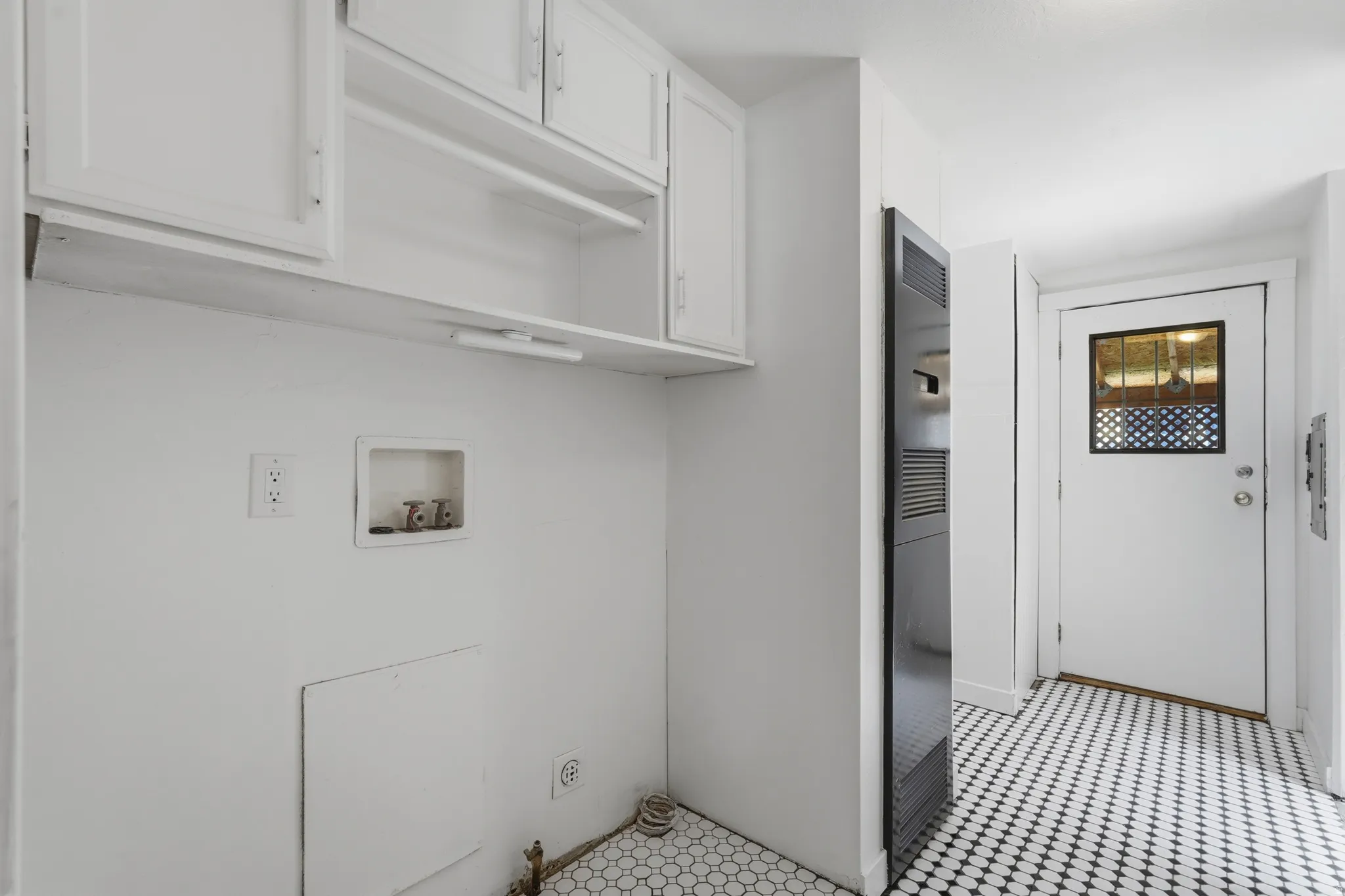 Utility area featuring white cabinetry, an integrated clothes rod, and a hexagonal tile floor