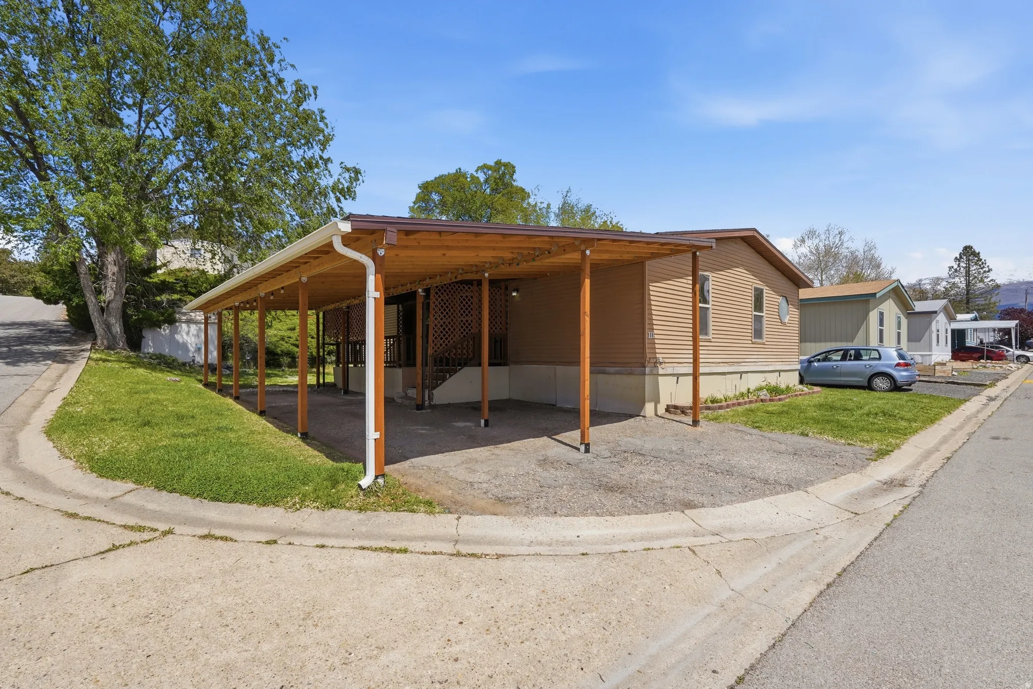 Property exterior featuring tan horizontal siding and a brown shingled roof