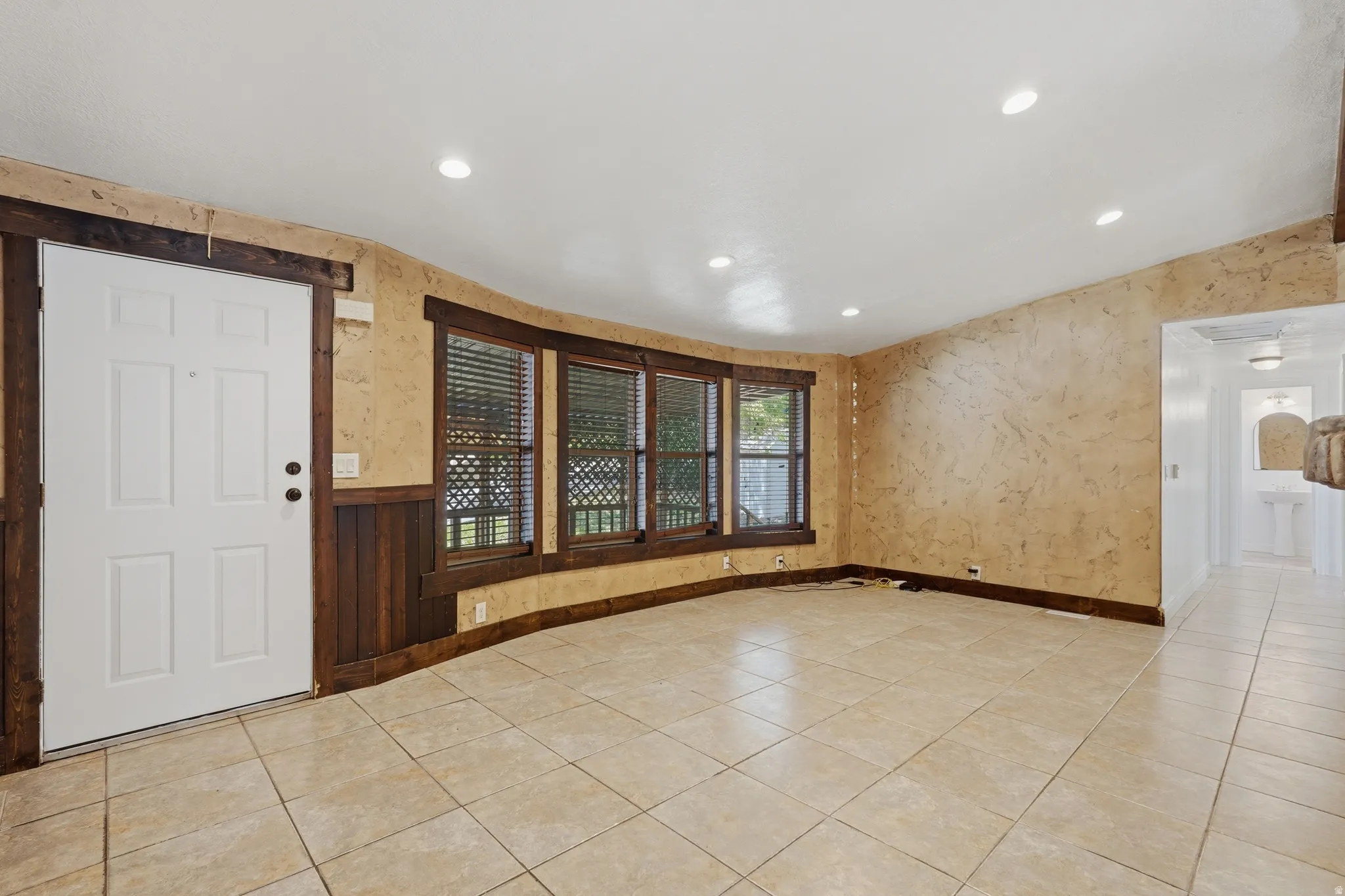Living area featuring recessed lighting, a multi-pane window with blinds, and tile flooring