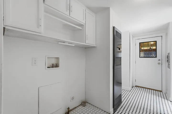Utility area featuring white cabinetry, an integrated clothes rod, and a hexagonal tile floor