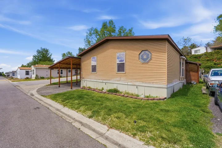 Tan siding exterior with a brown shingled roof