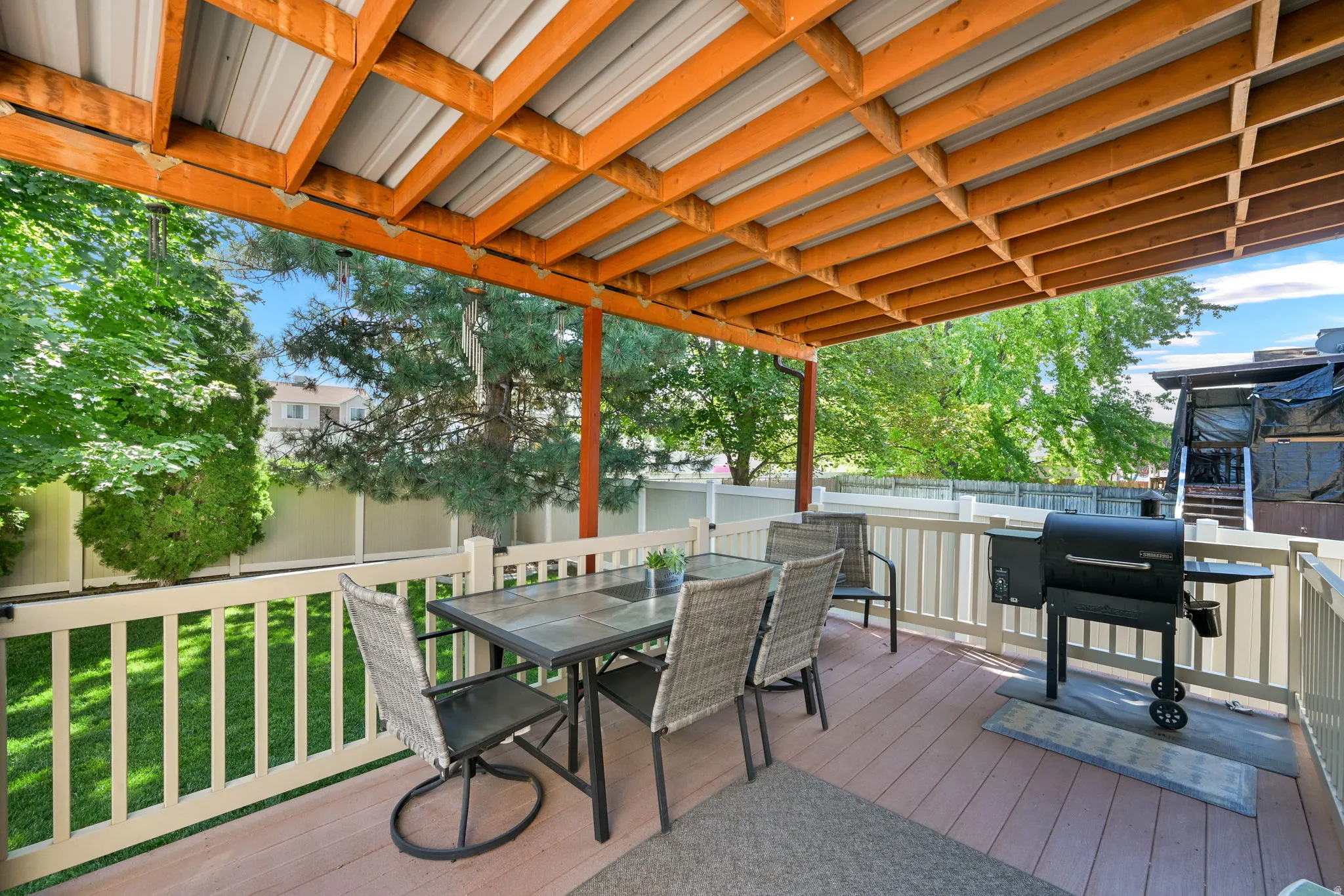 Expansive deck featuring a wood-beam and metal-panel roof structure
