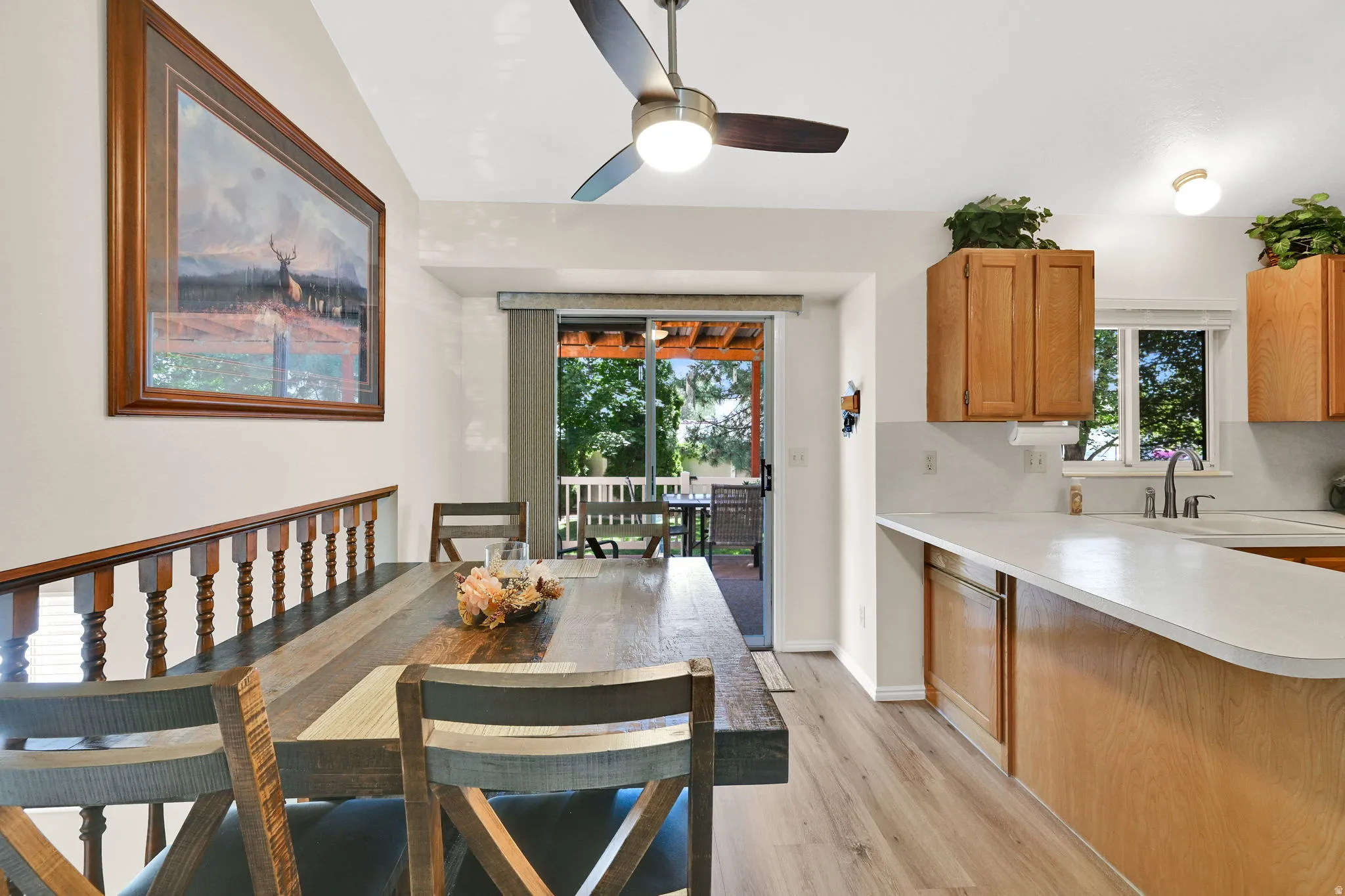 Open-concept dining area featuring a vaulted ceiling and wood-finish flooring