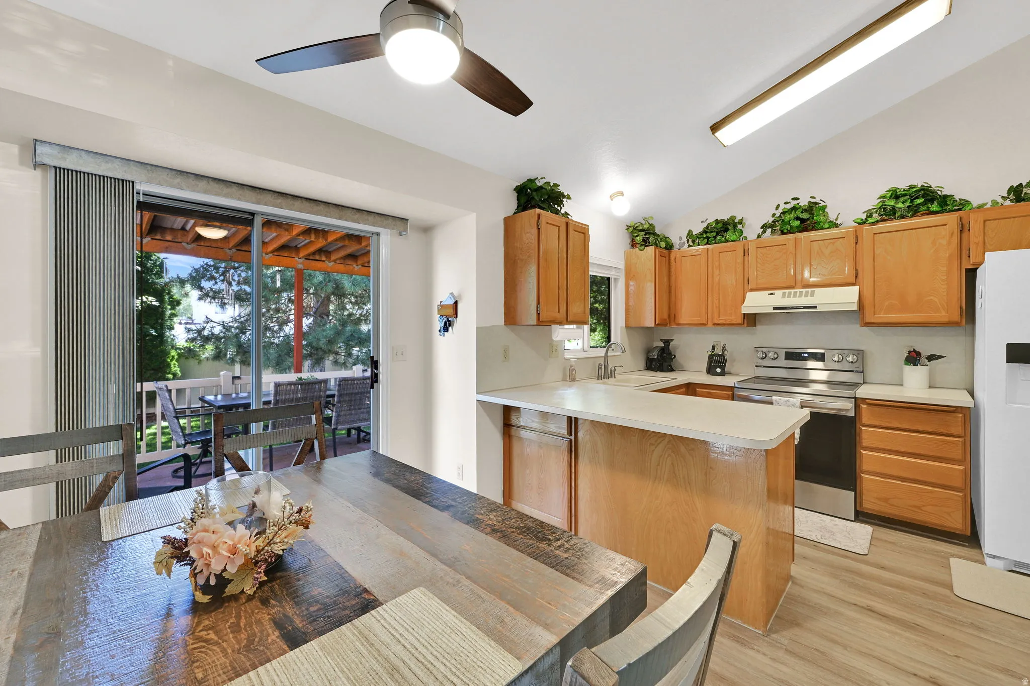 Bright and open kitchen featuring warm wood cabinetry, stainless steel appliances, and a spacious island with wood-finish countertop
