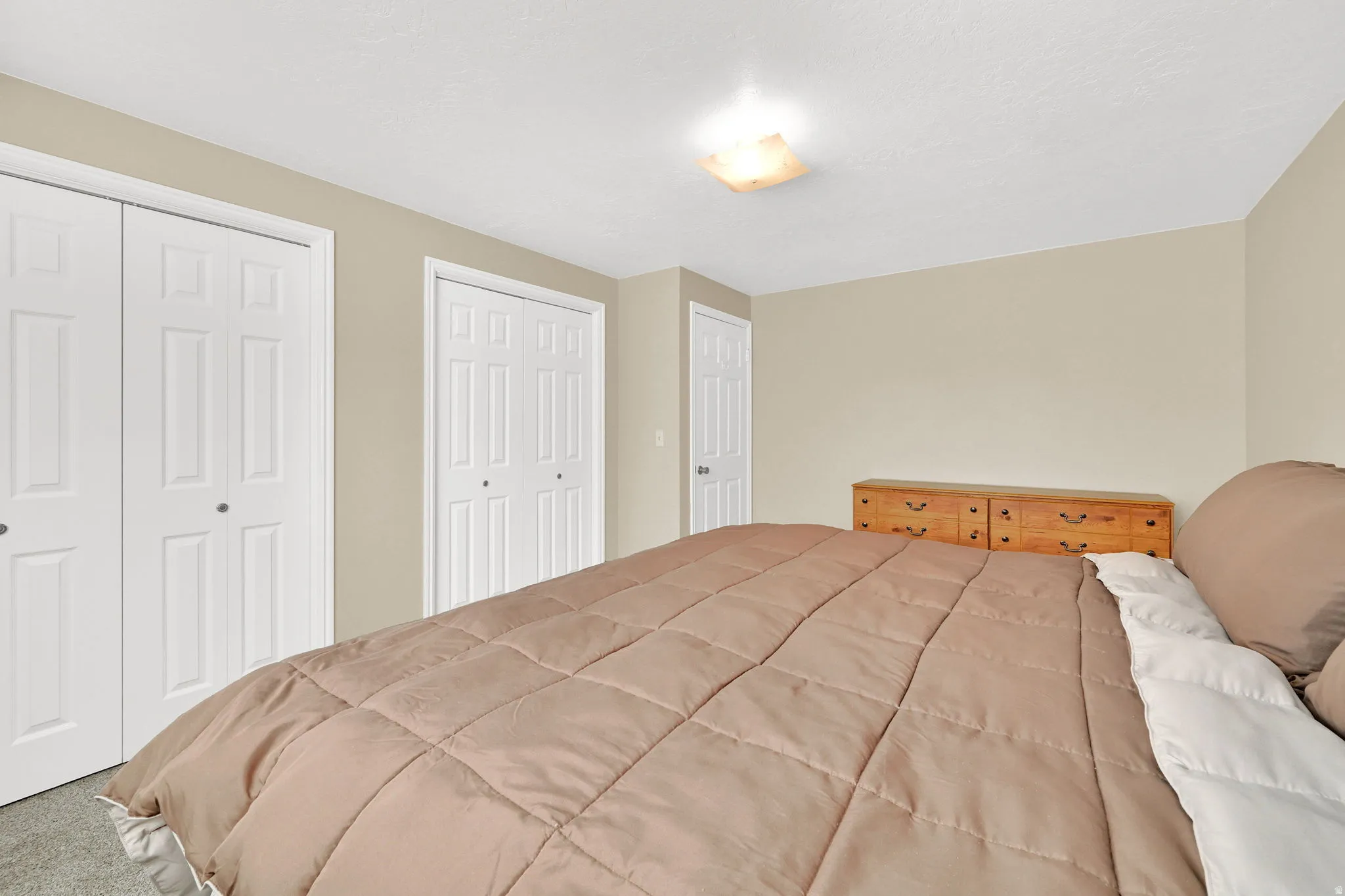 Neutral wall tones complement the white bi-fold closet doors
