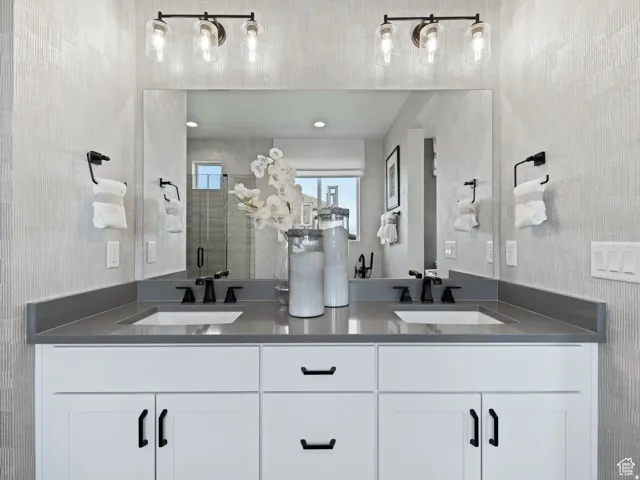 Double vanity featuring a wide mirror, gray countertops, and modern black fixtures