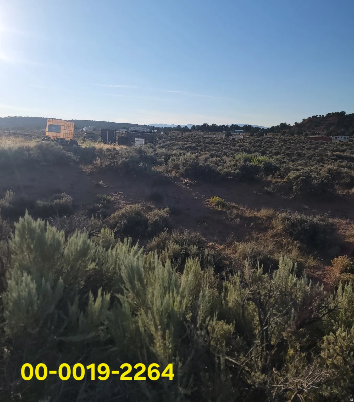 Expansive undeveloped land featuring natural desert vegetation, rolling terrain, and distant hills