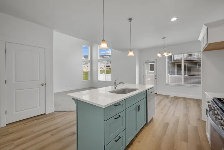 Kitchen island with light blue cabinetry, integrated sink, and white countertop