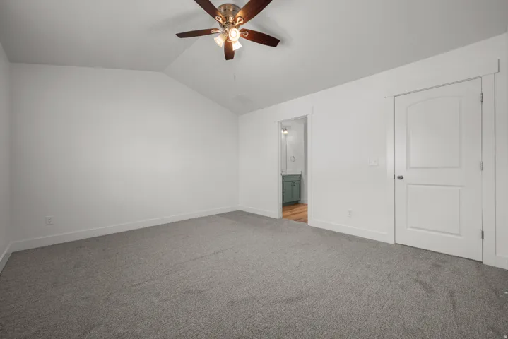 Spacious Master room featuring vaulted ceilings and neutral gray carpeting