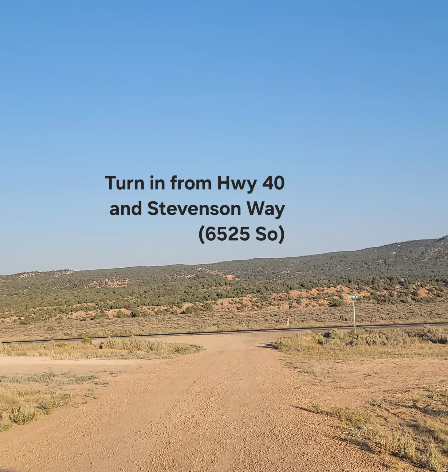 Expansive desert landscape featuring a dirt road and distant hills