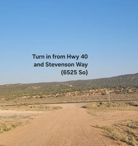 Expansive desert landscape featuring a dirt road and distant hills