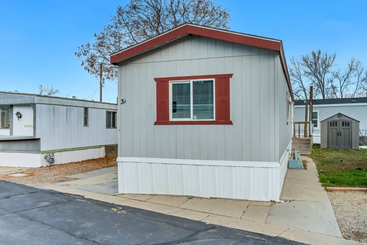 Light grey vertical siding with contrasting red trim and shutters