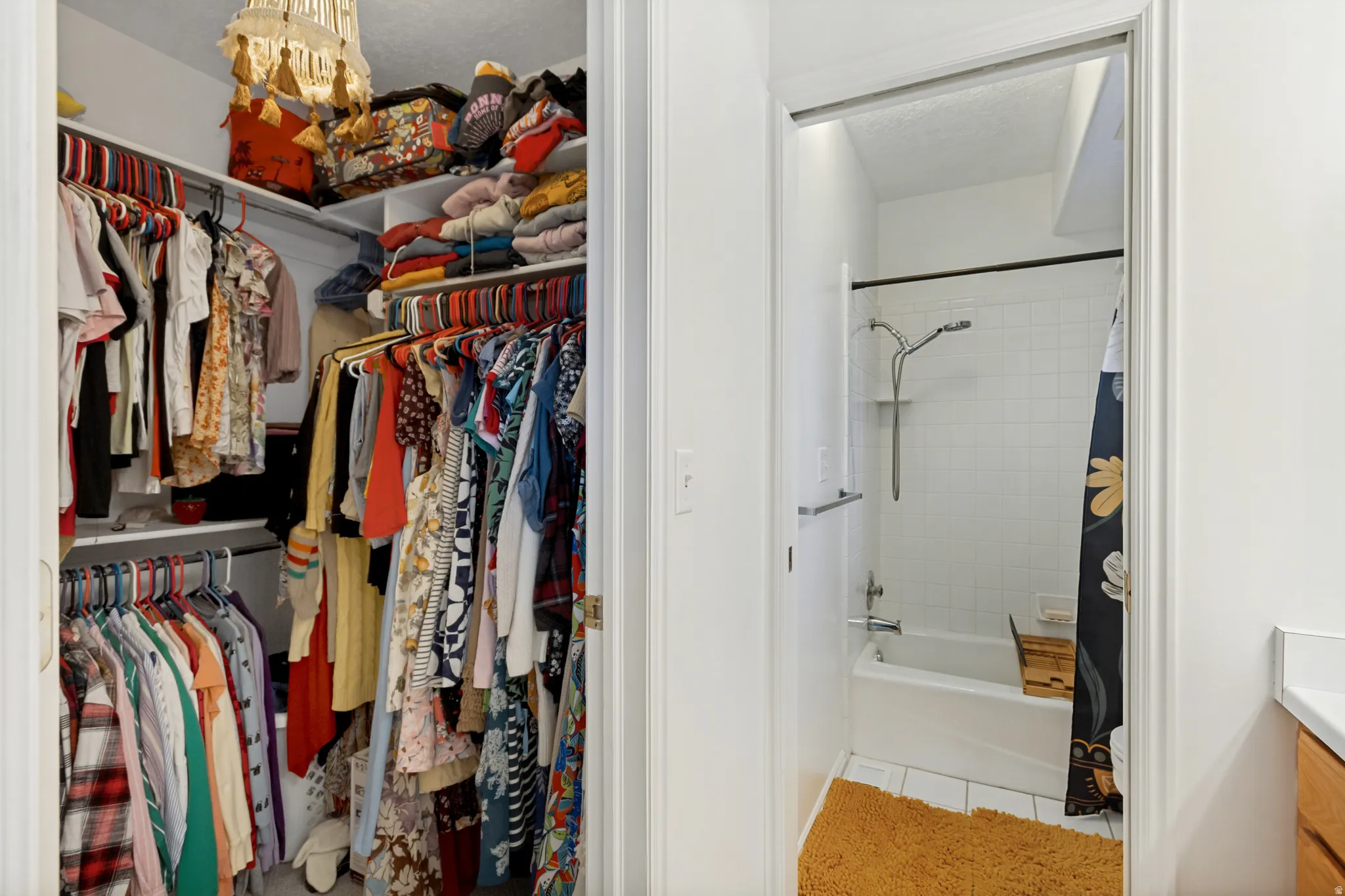 Spacious reach-in closet featuring extensive built-in shelving, hanging rod systems, and ample storage capacity for clothing and accessories