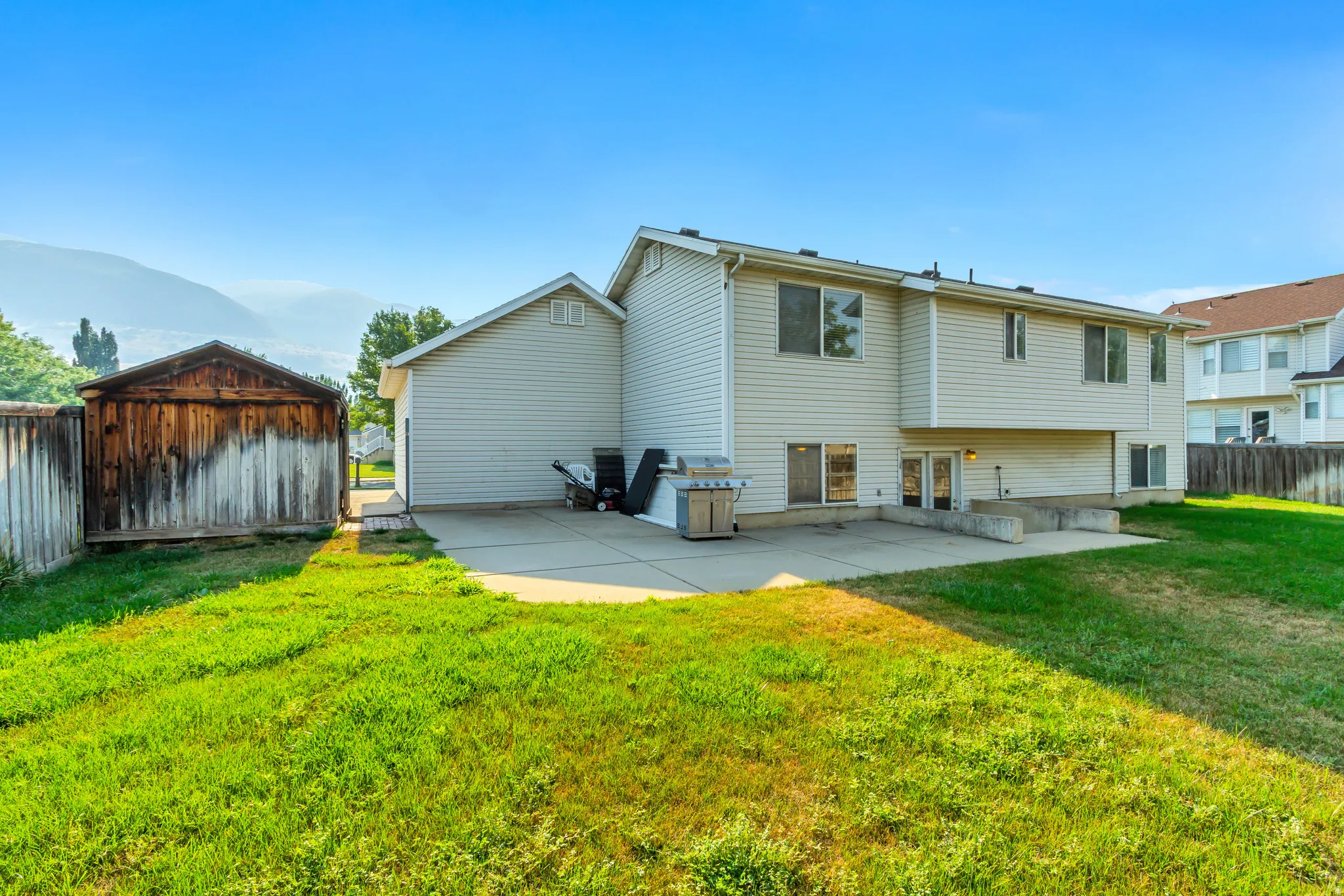 Spacious two-story home with vinyl siding exterior, attached two-car garage, and expansive concrete patio