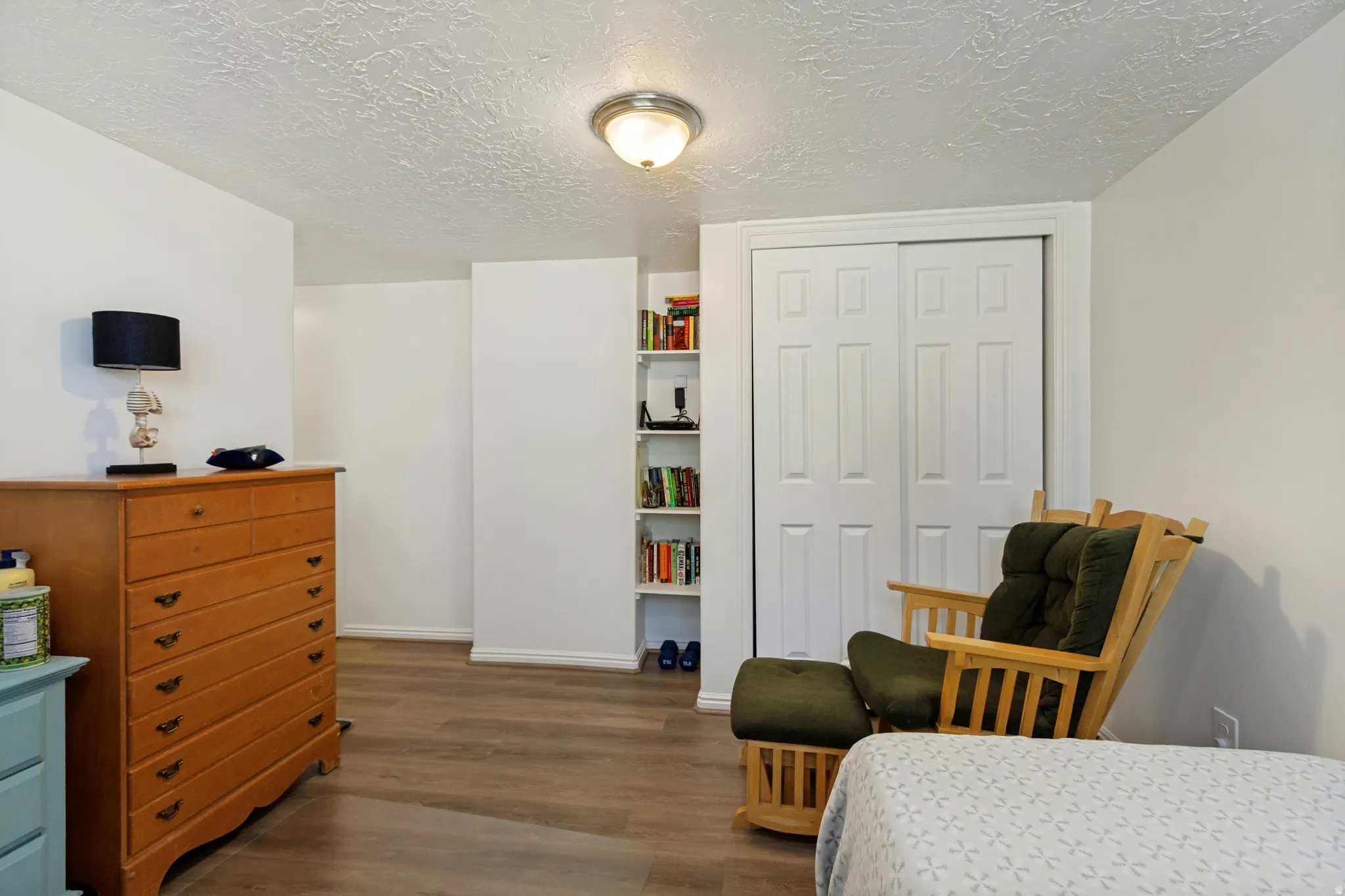 Spacious bedroom showcasing wood-finish flooring, ample natural light, and versatile layout