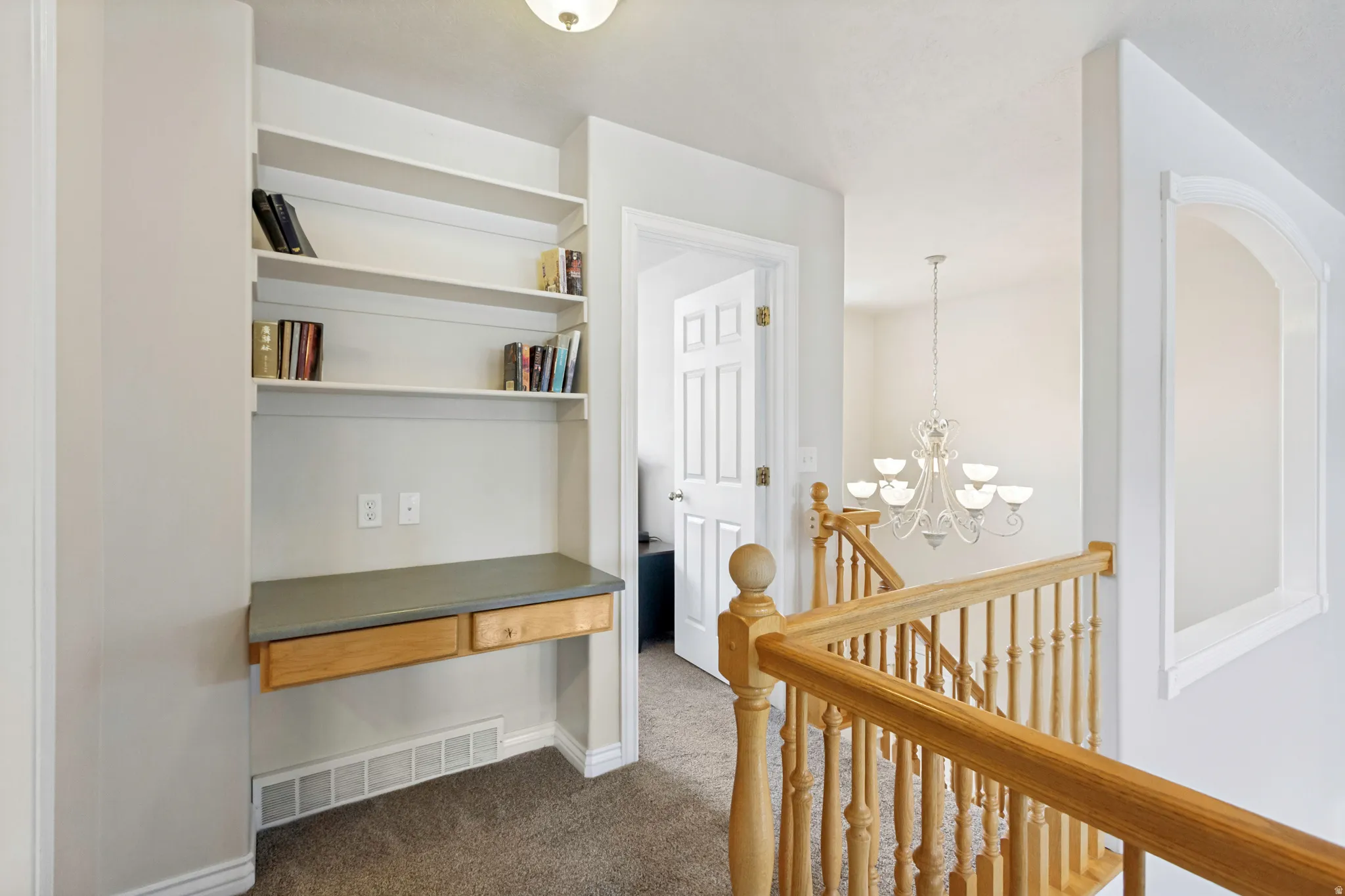 Built-in desk area featuring shelving and a light wood-finish countertop with two drawers
