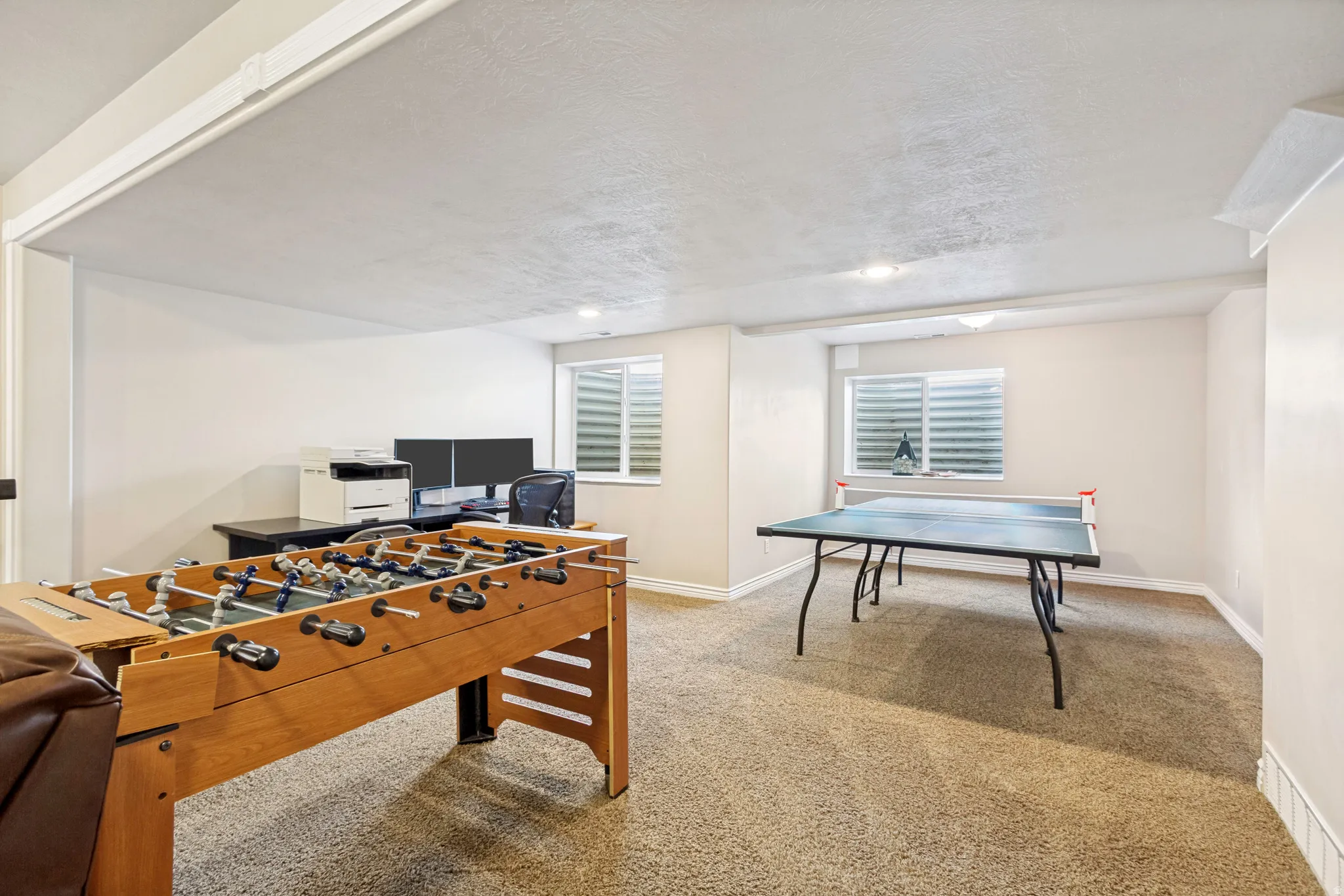 Spacious room with light-toned walls and neutral carpet flooring