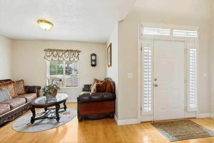 Entryway featuring a white door with sidelights, transom windows, and white plantation shutters