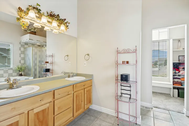 Double vanity featuring wood cabinetry and an integrated countertop