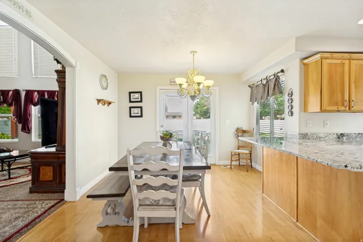Dining area featuring wood-finish flooring, a contemporary chandelier, and French patio doors