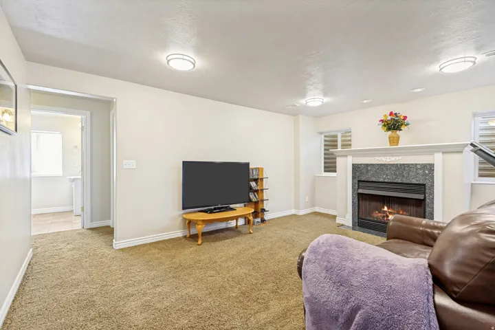 Living area featuring a floor-to-ceiling fireplace with a granite surround and a white mantle