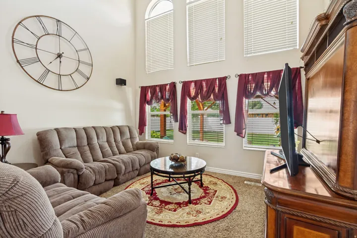 Living area featuring high ceilings with multiple windows, including an arched window