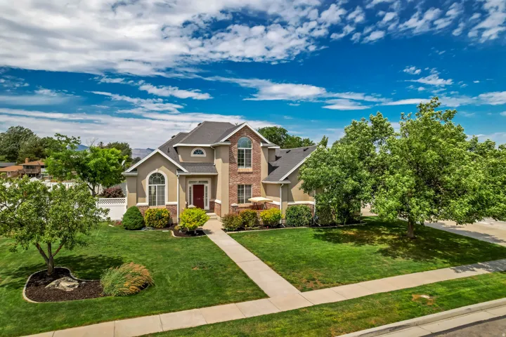 Contemporary stucco and brick exterior featuring a red entry door, arched windows, and a paved walkway